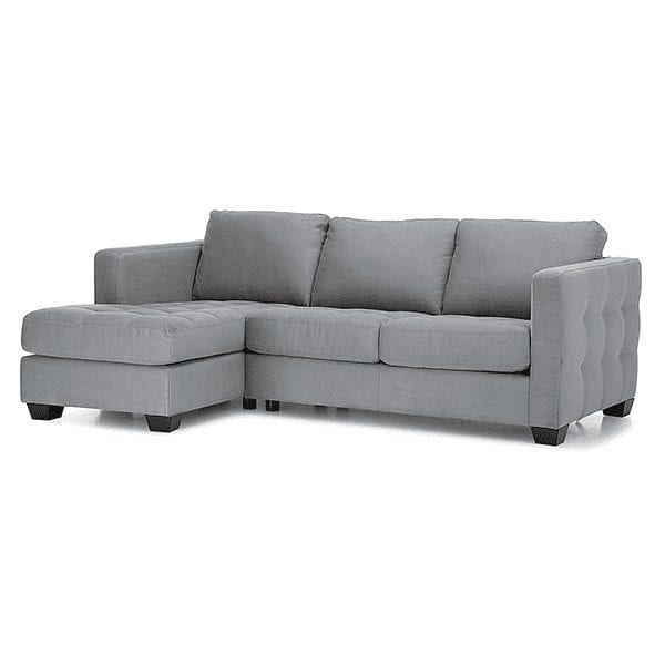 Grey, upholstered, 3 cushion, tufted back sofa with chaise on left side.